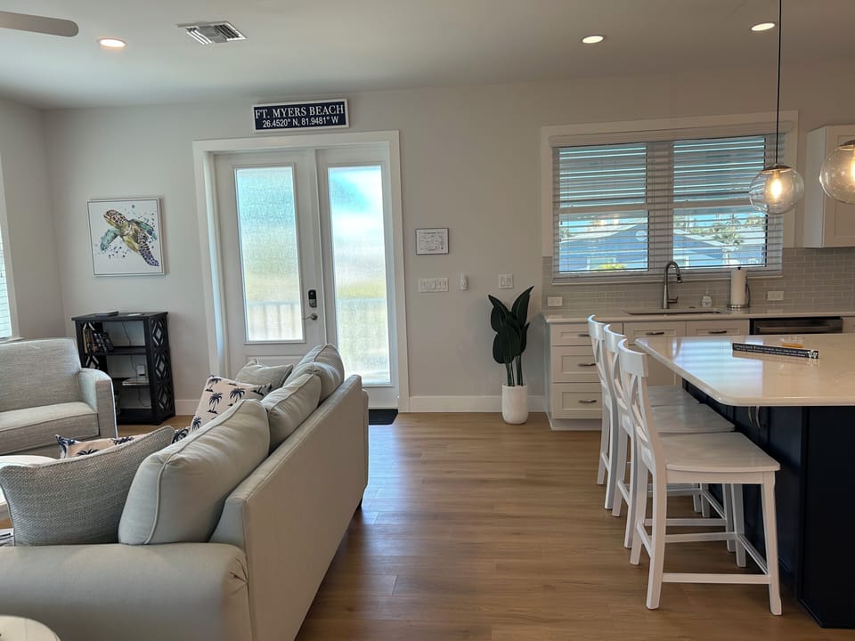 View of kitchen and living room with front door.