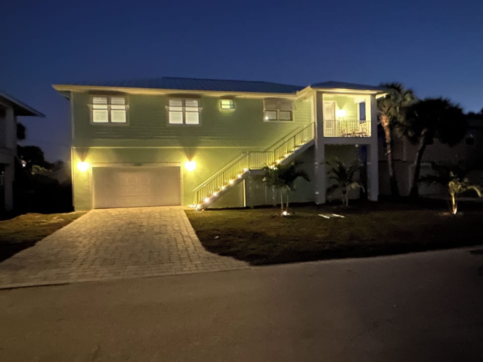 Picture yourself here, front of home view with palm trees swaying in the wind.