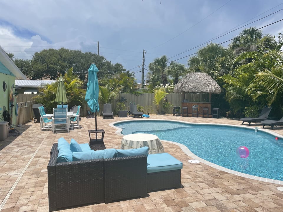 Large fenced yard with heated private pool, tiki bar, lounging fire pit and more