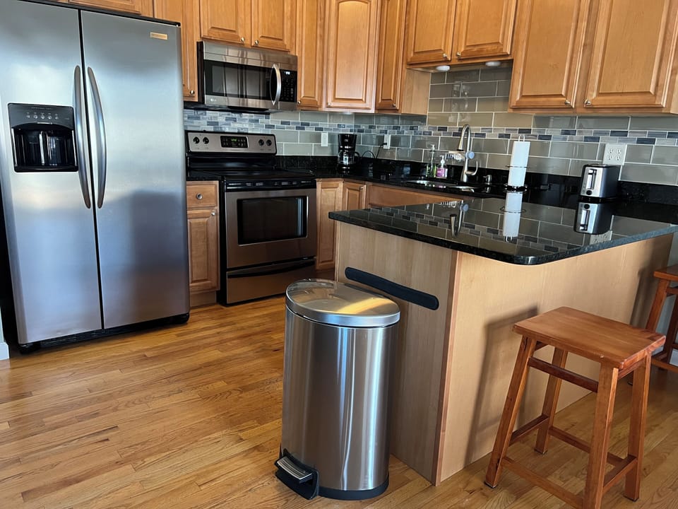 Modern kitchen with granite counters. New backsplash added in 2025.
