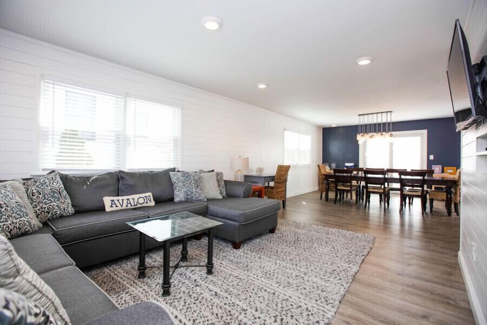 Open concept living with large sofa, TV, and desk area - Work from the beach!