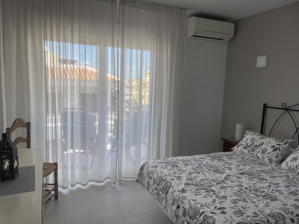 Bedroom with patio doors leading to corner balcony.