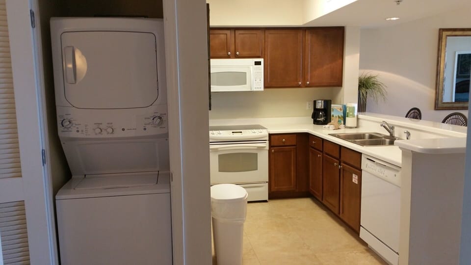 Stacked washer and dryer adjacent to kitchen