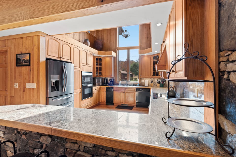 The kitchen features massive granite counters & a sit down breakfast bar area.