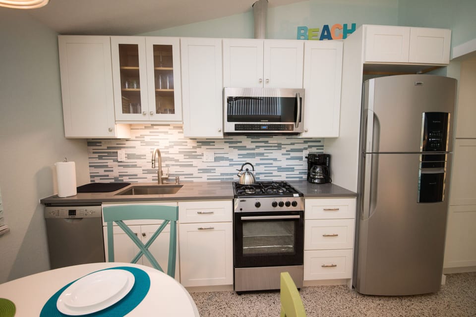 Full kitchen with natural gas range, ducted range hood.