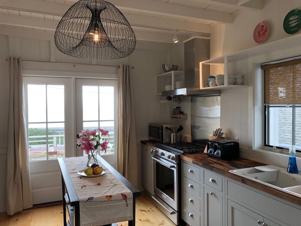Kitchen with sea view, access to porch, outdoor dining.
