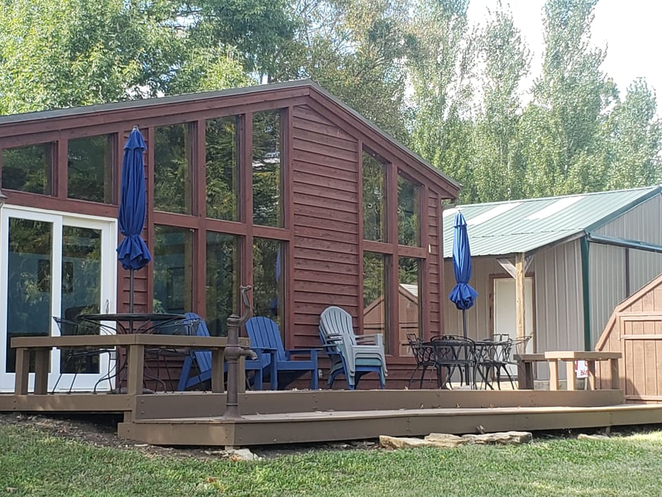 Back of cabin with great deck, picnic tables, hot tub, and gas grill.
