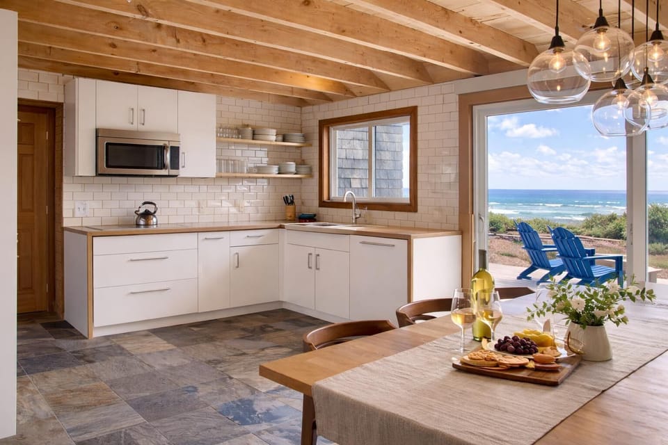 Bright Coastal Kitchen and Dining Area with Ocean Views and Direct Access to Deck—Perfect for Cooking, Gathering, and Stepping Outside to Enjoy the Pacific.