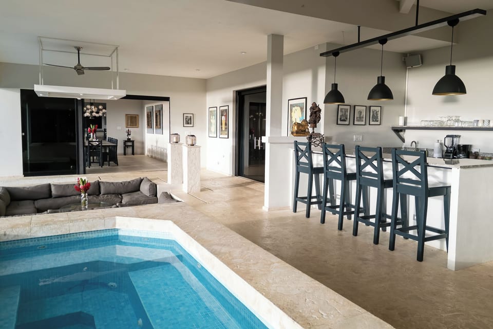 Open-concept bar and lounge with indoor–outdoor flow and whirlpool 14+ seating