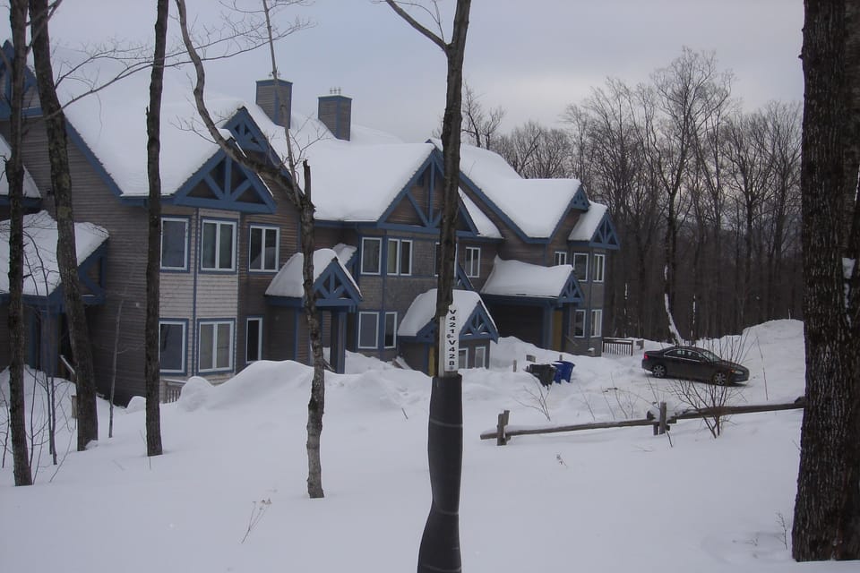 View of condo building & private parking lot from the Grammy Jay trail (on skis)