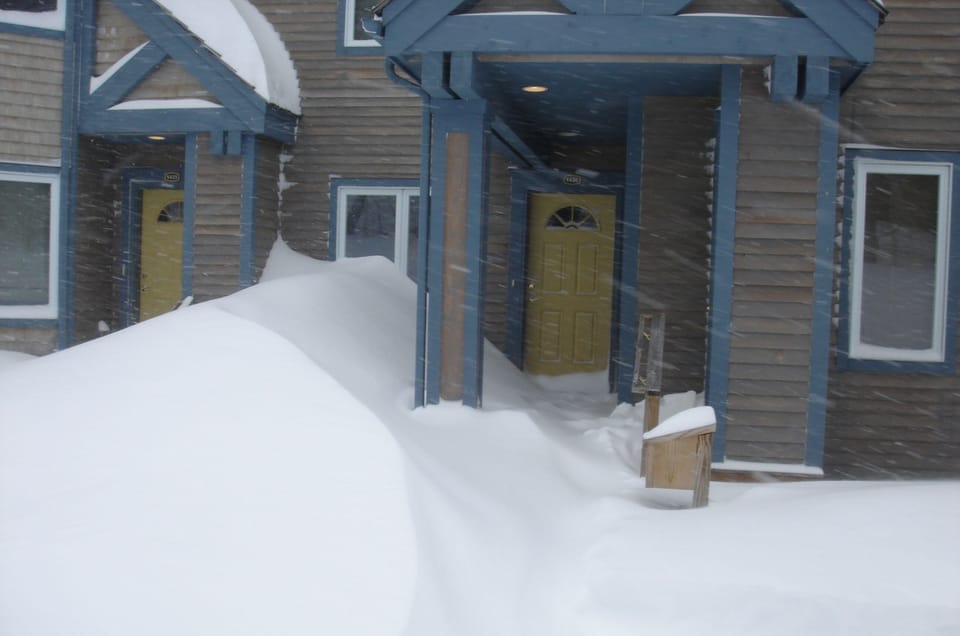 View of front door & porch from parking spot, ski locker is on the right.