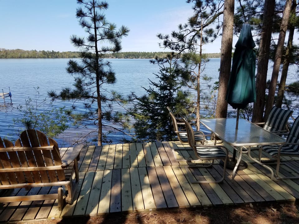Lake side deck with table, chairs, umbrella, glider, and incredible lake view!