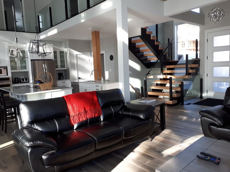 Living room seating with 2 couches and 1 loveseat - looking towards the kitchen