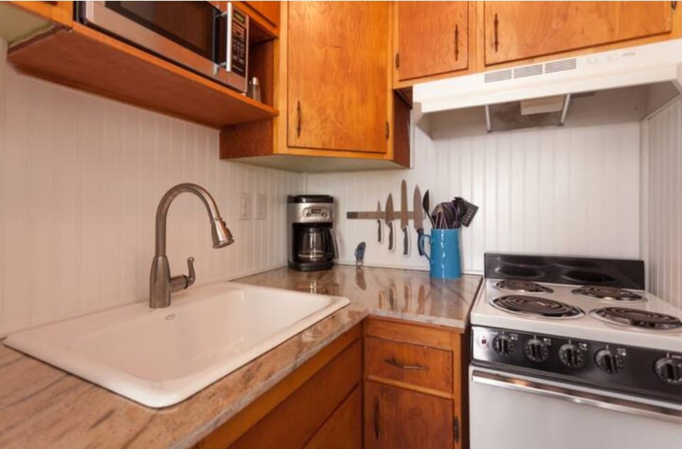 Kitchen with stove, refrigerator and microwave.