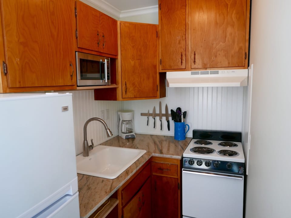Full kitchen with granite counter, sink, stove, oven, microwave and refrigerator
