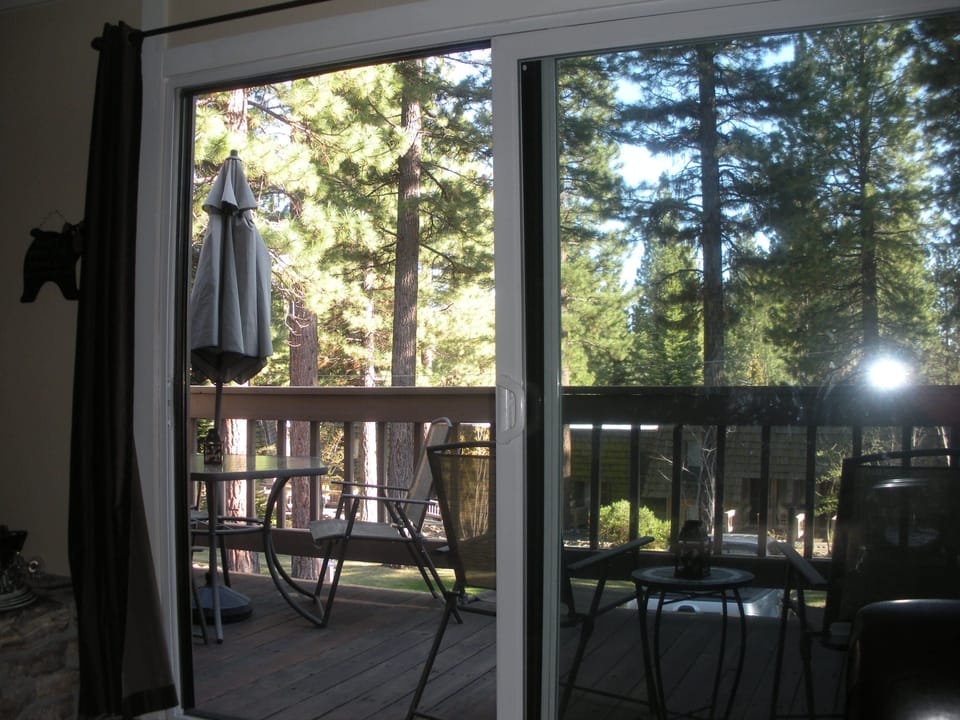 Outdoor deck with seating and gas grill overlooking greenbelt
