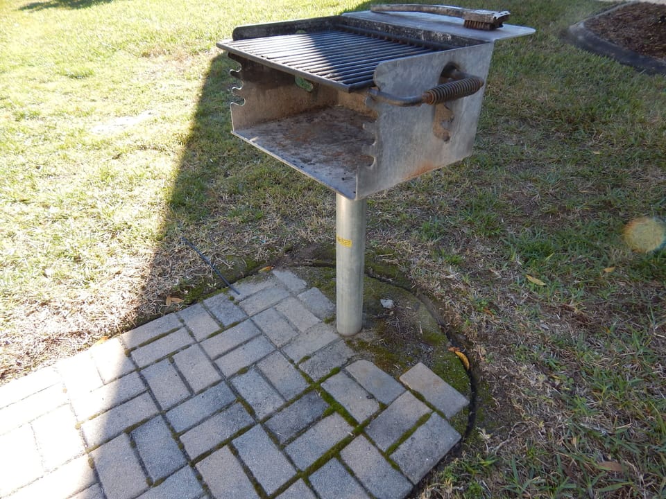 Park-style charcoal grill next to lanai area