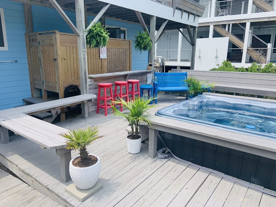 Hot tub deck with outside shower and foot rinse.