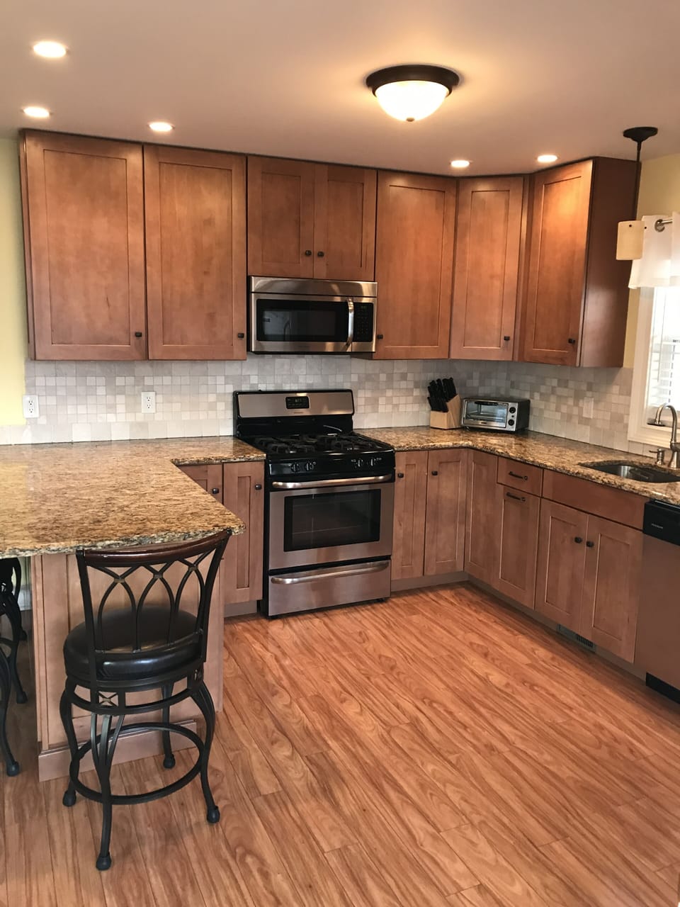 LARGE KITCHEN WITH GRANITE COUNTERTOPS AND TILE BACKSPLASH. STAINLESS APPLIANCES