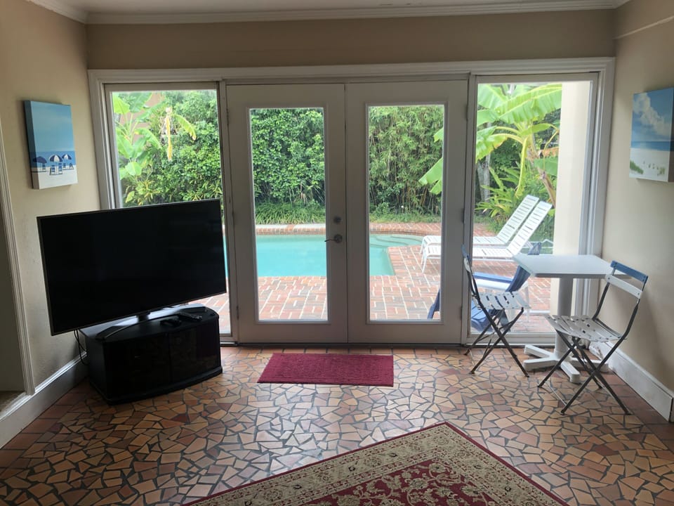 Watch the kids in the pool from this TV room right off the kitchen. 