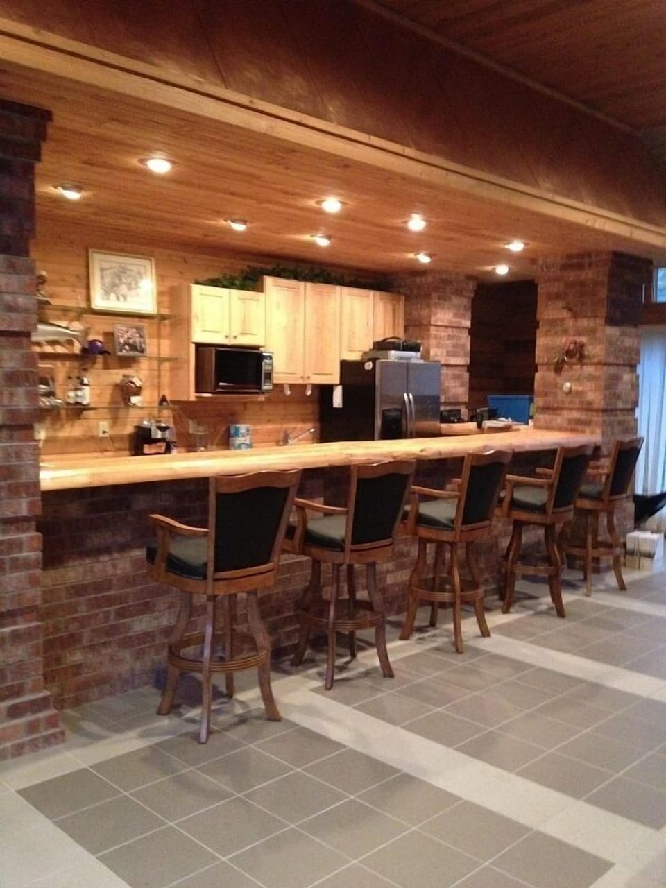 Bar located next to living room. Comfortable bar seating & full fridge/freezer 