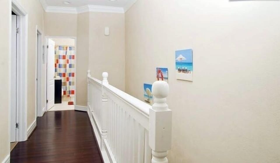 UPSTAIRS HALLWAY WITH CUSTOM BUILT RAILS TO COMPLEMENT THE CHOC. HARDWOOD FLOOR