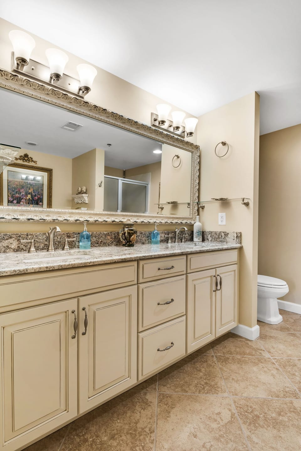 Master bath has full-length beveled mirror encased in frame & new light fixtures