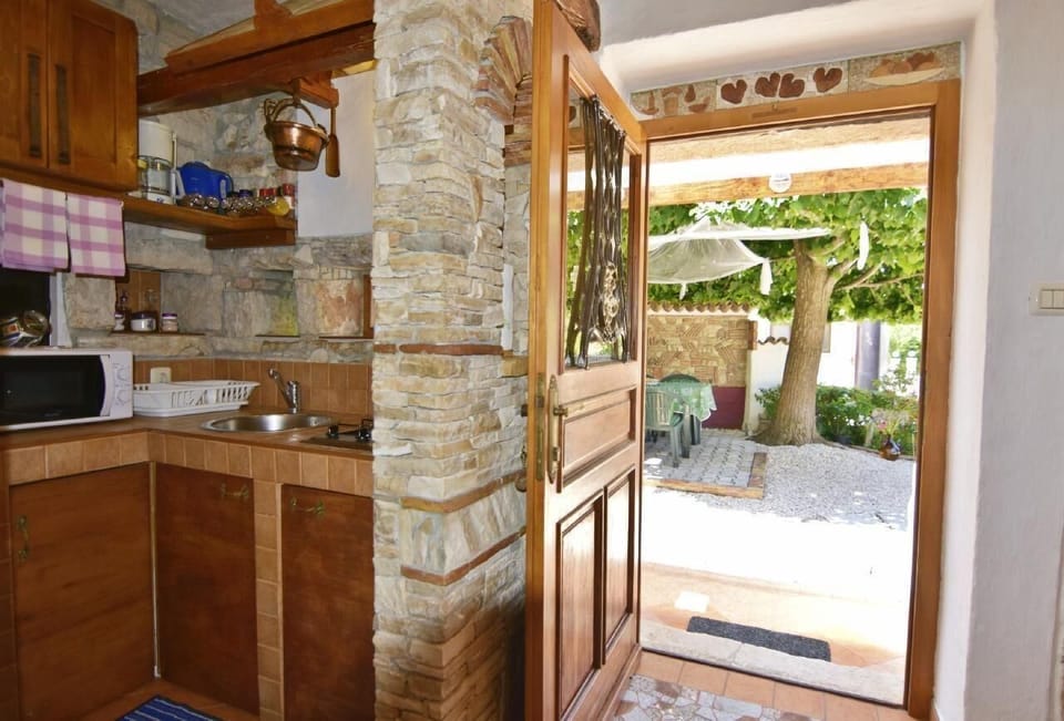 The kitchen and exit to the garden with table and chairs under the mighty tree