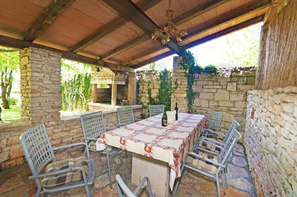 Covered terrace with a stone built fireplace and grill