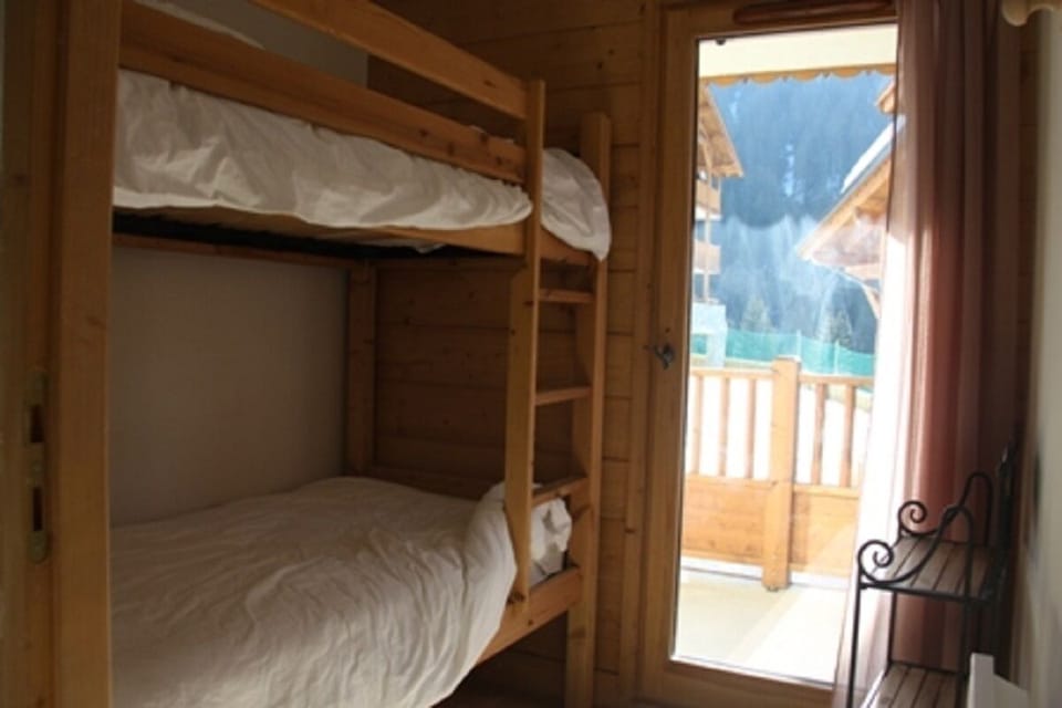 Bedroom with bunk beds and a patio door with the east-facing balcony access