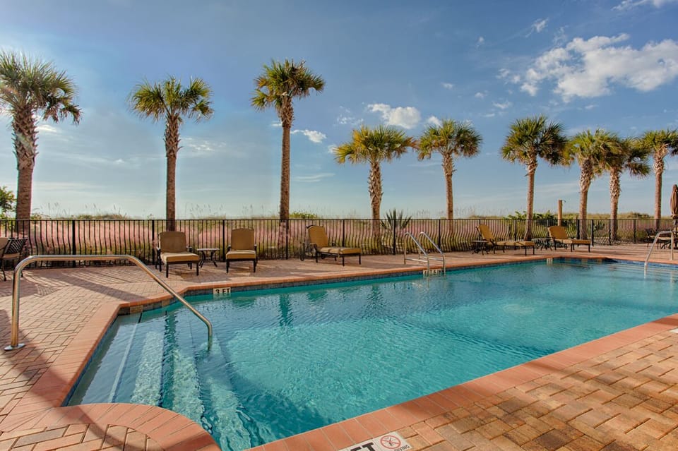 Beach side pool with comfy lounge chairs.