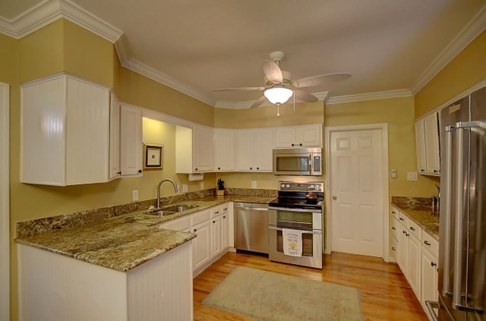 Gourmet kitchen equipped with all modern stainless appliances and cookware