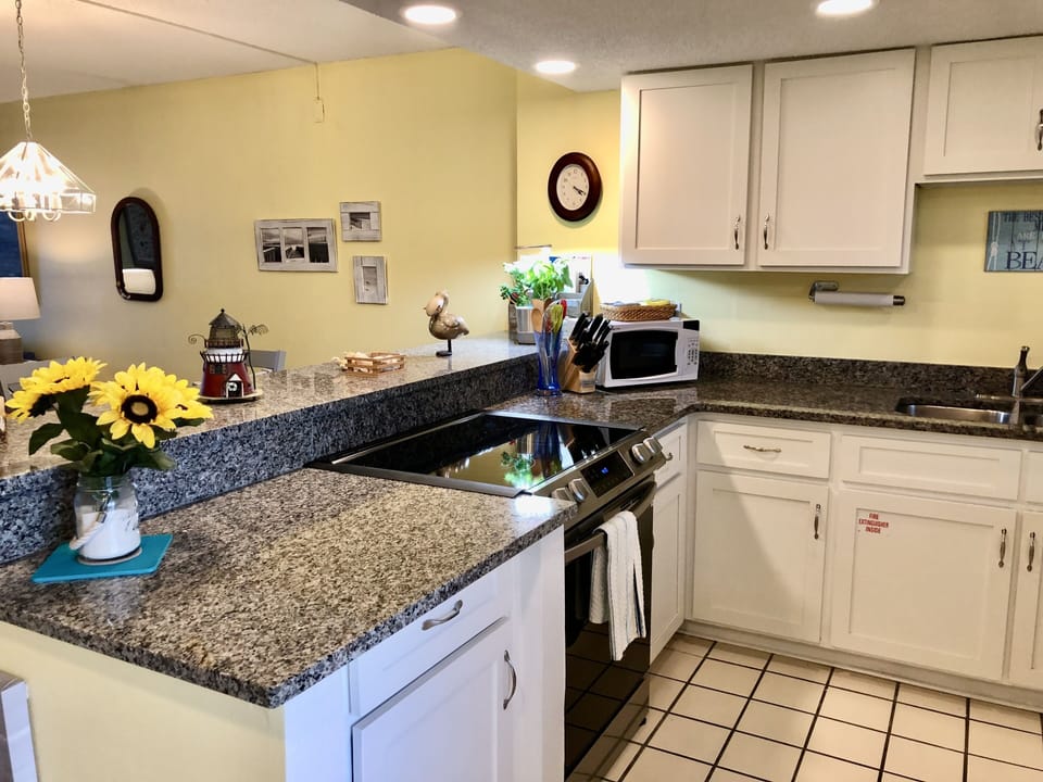 Kitchen with ceramic-top stove and miocrowave.