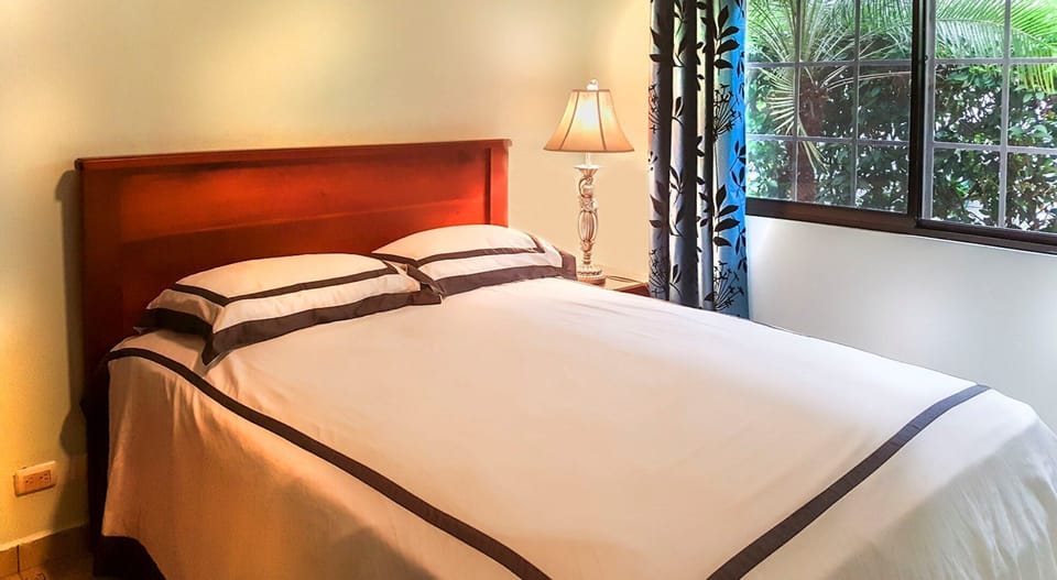 Window bright 2nd bedroom with wardrobe and views of our palm and banana trees
