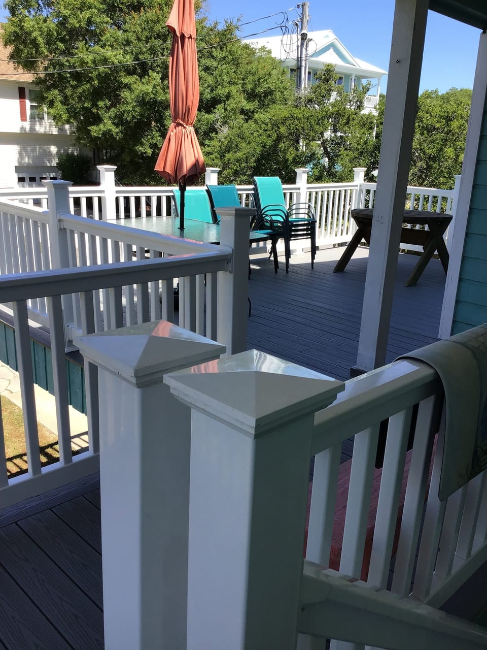 back deck area with tables , umbrella and chairs