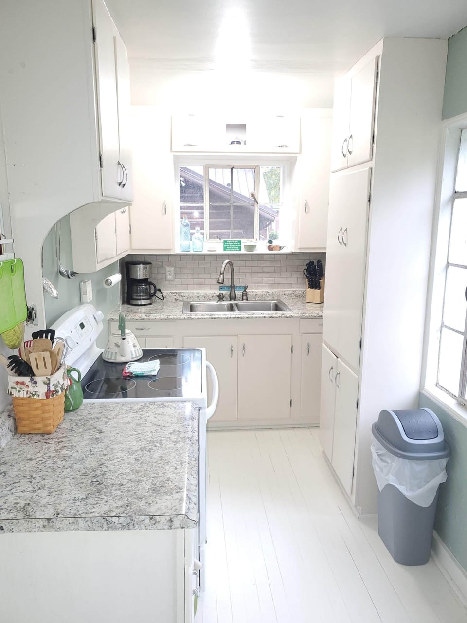 Kitchen stocked with pots, pans, everyday dishes, toaster, microwave, coffee pot
