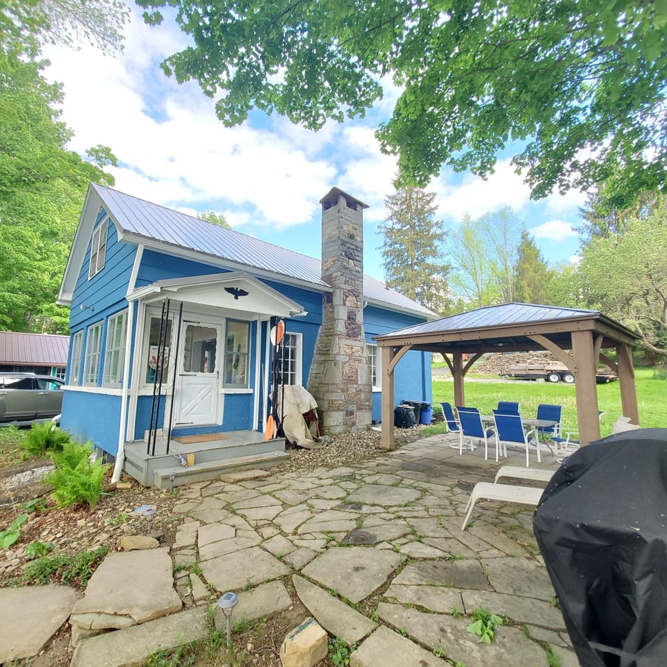 Patio with covered gazebo, dining table, gas grill and lounge chairs
