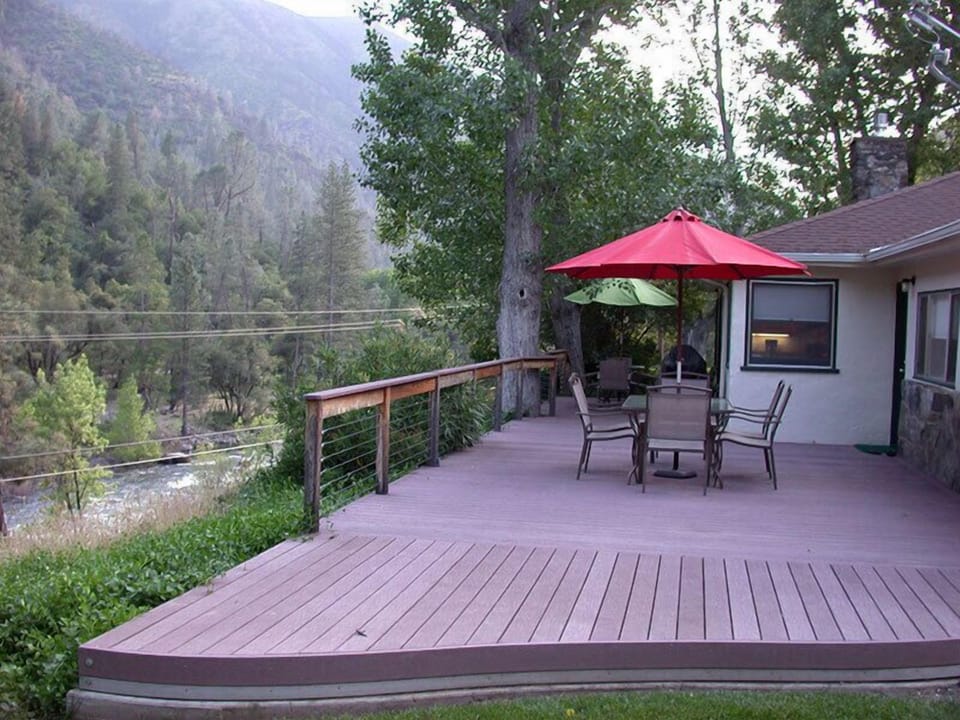 Large deck with two dining tables, BBQ, and big views of river and mountains