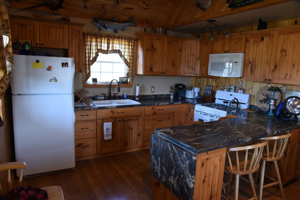 Full kitchen - fridge, sink, microwave, stove, keurig & breakfast bar.