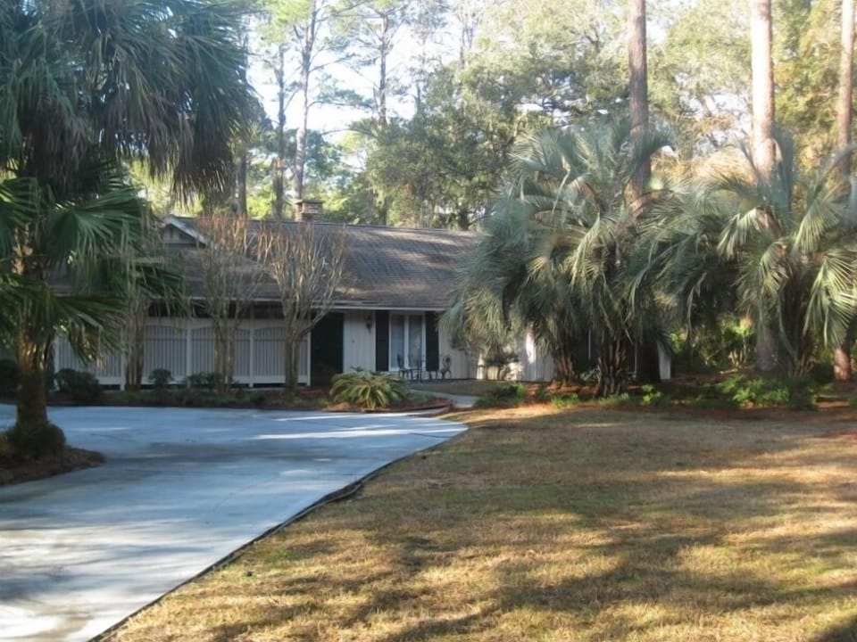 The house is set back from the road with a large circular drive.