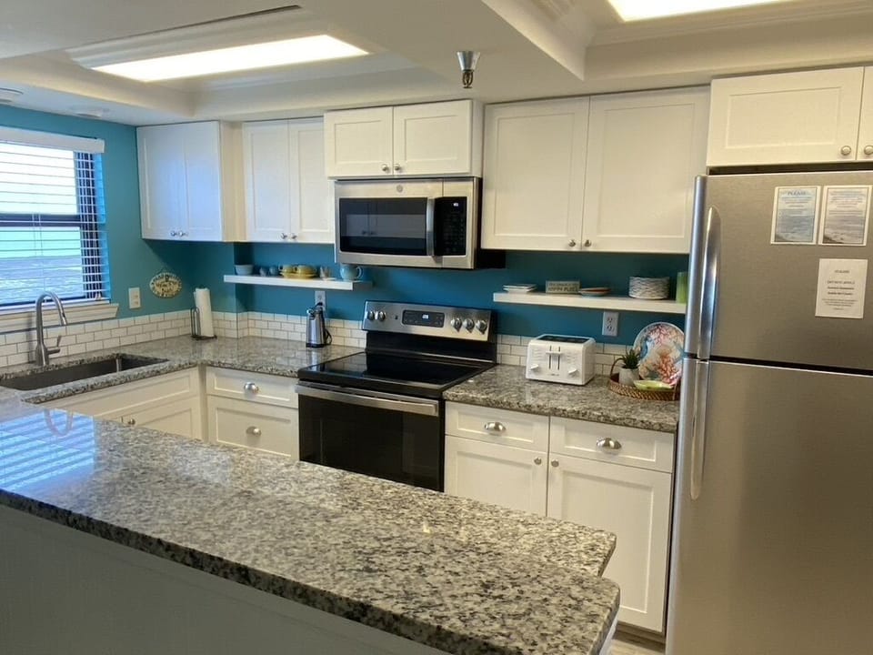 New range, microwave, dishwasher, shaker cabinets and granite countertops