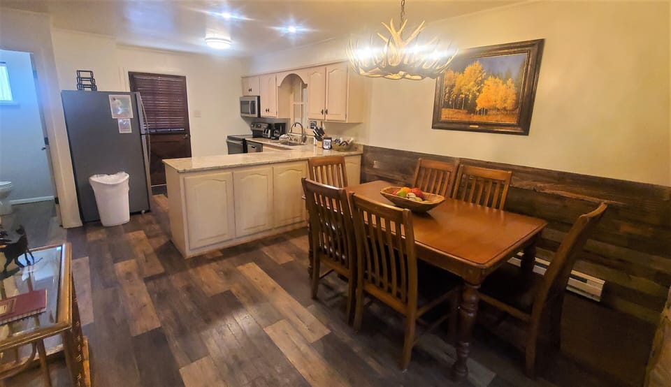 Gather around your private dining table in this cozy kitchen space, where home-cooked meals and morning coffee await beneath warm lighting and rustic mountain charm.
