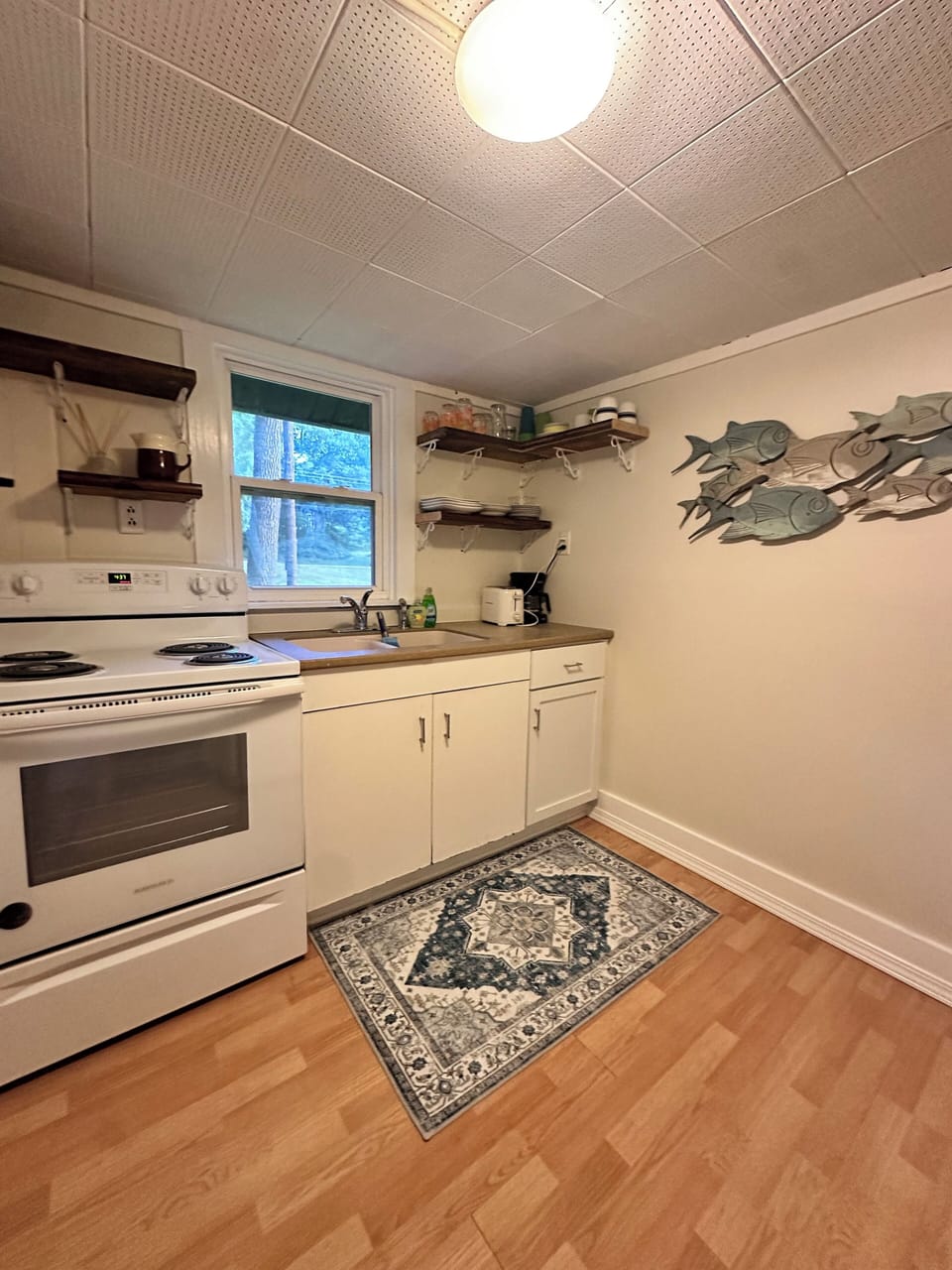 kitchen with electric stove, refrigerator, microwave, and coffee maker 