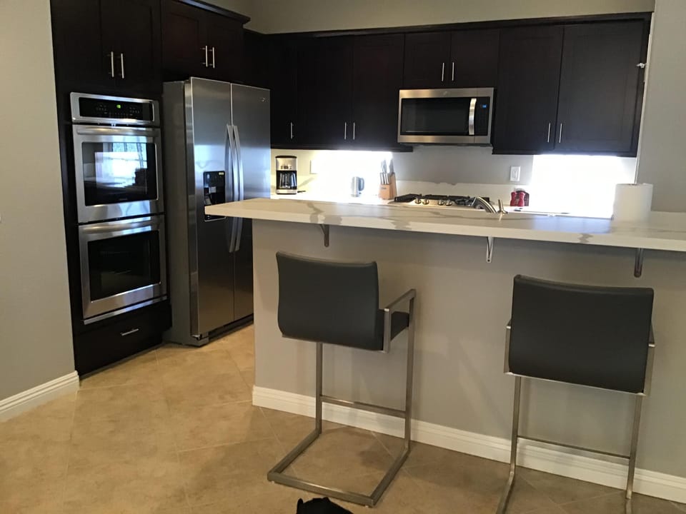 Kitchen: stainless steel appliances, espresso maple cabinets & quartz countertop