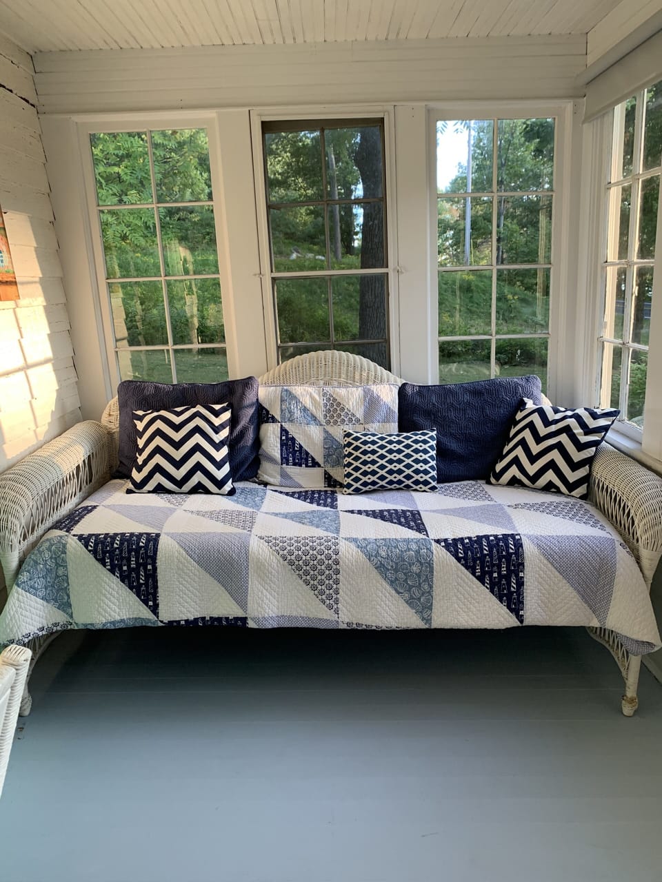 Daybed on the second section of the front porch, with a game table and desk 