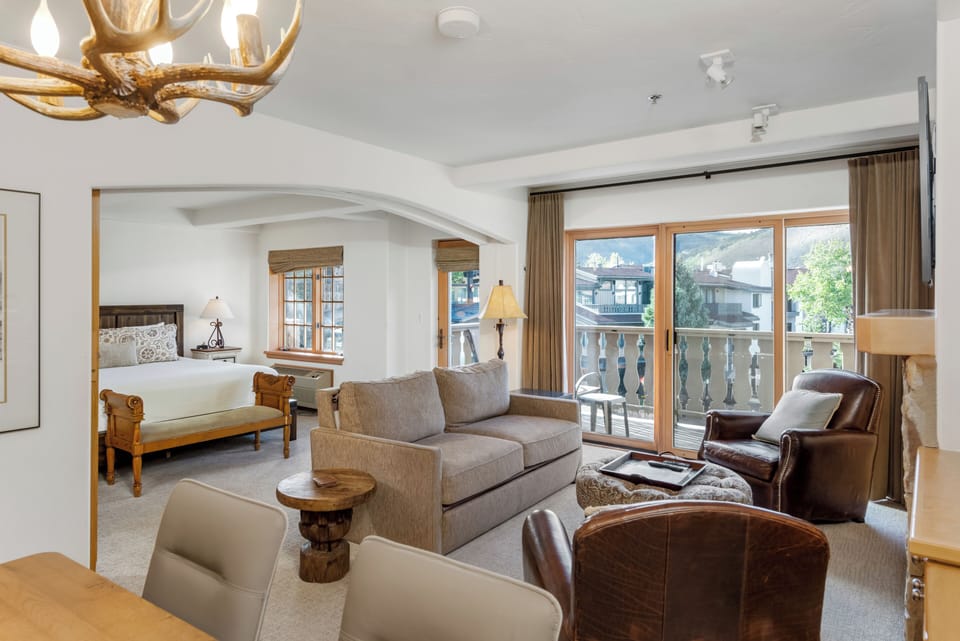 Unwind in your spacious suite where rustic alpine charm meets modern comfort. Sink into plush seating, step onto your private balcony for mountain air, and enjoy an open layout that seamlessly blends living and sleeping spaces.