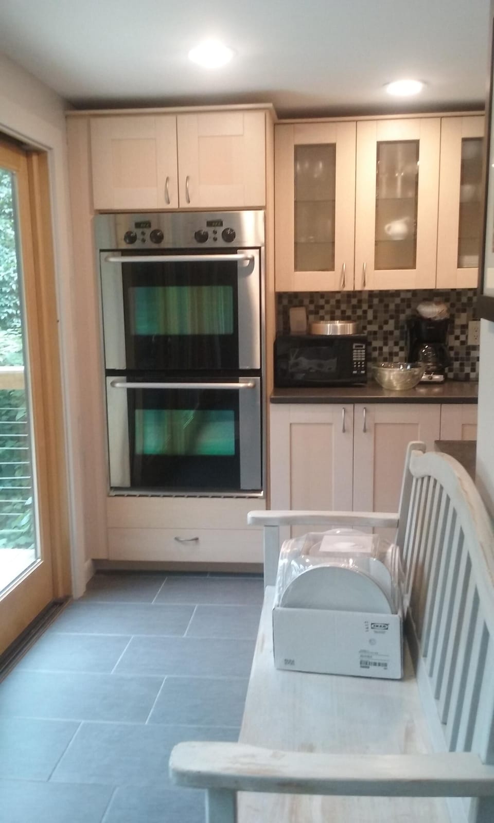 View from the dining nook to double ovens. Very bright kitchen and dining area.