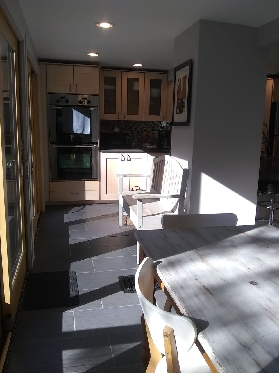 A view from the dining table to one end of the kitchen. Wall of glass sliders.