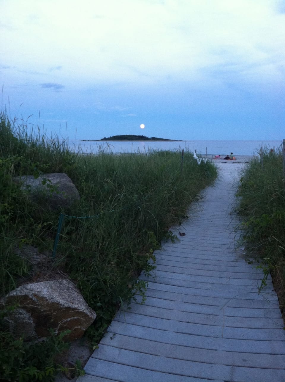 Goose Rocks Beach in the evening and a full moon setting over Timber Island .