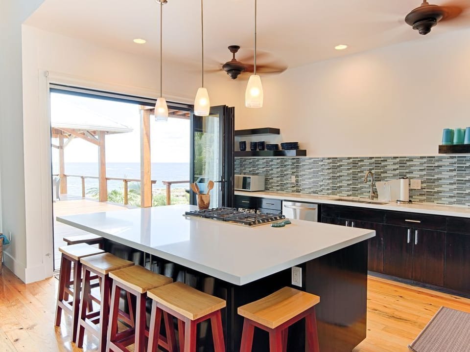 🌿 A gourmet space featuring a large social island, premium stainless steel appliances, and quality cookware. The open design keeps you connected to the Great Room and ocean views while you prep island-fresh meals. 🥂
